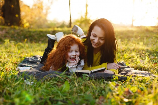 가을 분위기, 가족 초상화. 매력적인 엄마와 그녀의 빨간 머리 딸은 타락한에 앉아 재미있다
