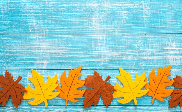 色のフェルトの葉を持つ秋の木製の背景