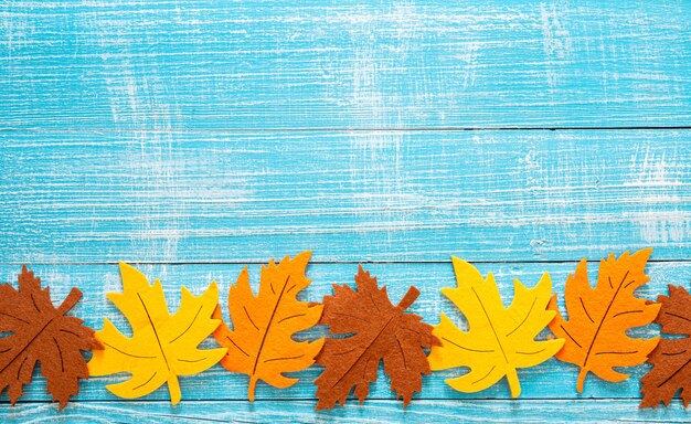 Autumn wooden background with colored felt leaves