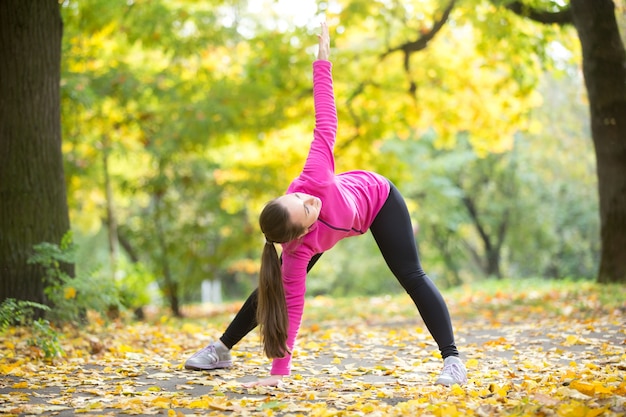 Free Photo  Girl stretching feet with a yellow resistance band on the yoga  mat in a lawn