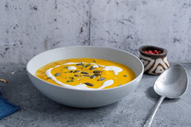 Autumnal soup in bowl on grey background