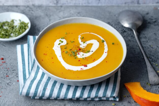 Autumnal soup in bowl on grey background