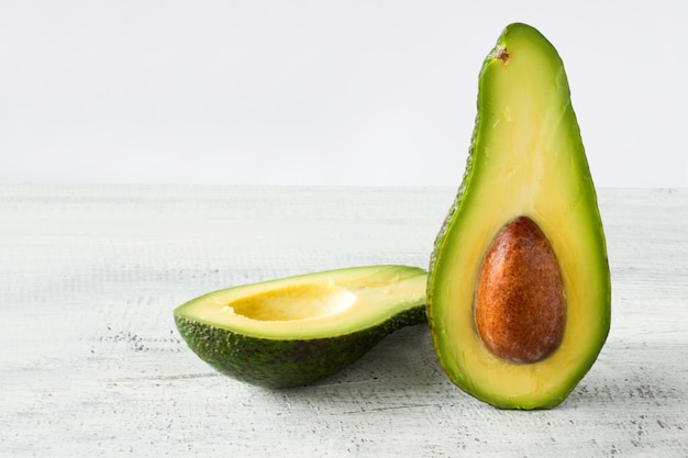 Avocado food background with fresh organic avocado on old wooden table, copy space