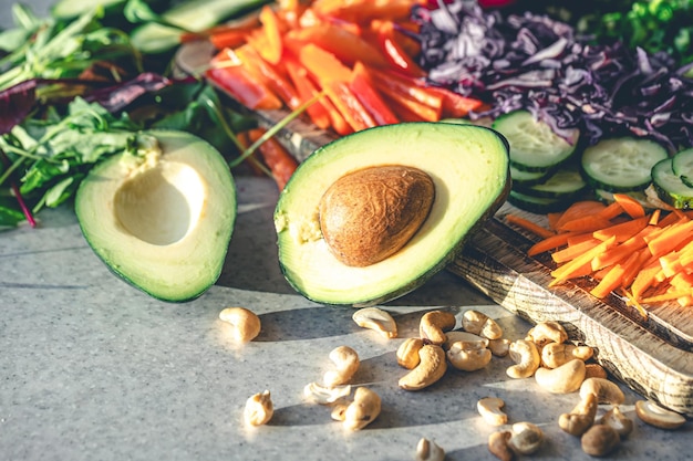 Free photo avocado halves on the kitchen table with chopped fresh vegetables