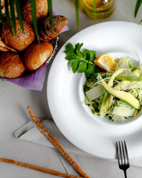 Insalata di avocado con formaggio grattugiato e limone servito con pane 1