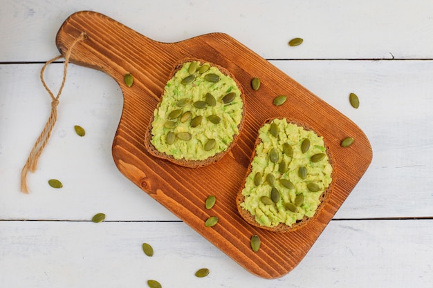 Avocado toast on whole grain bread with vegetables,yellow and red tomatoes