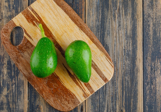 Avocados on wooden and cutting board. flat lay.