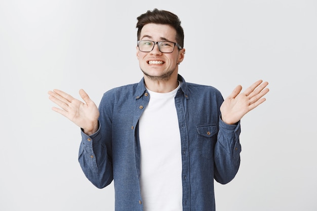 Free photo awkward guilty guy apologizing with hands raised up