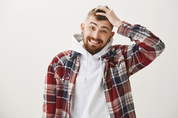 Awkward worried guy make forced smile and looking guilty