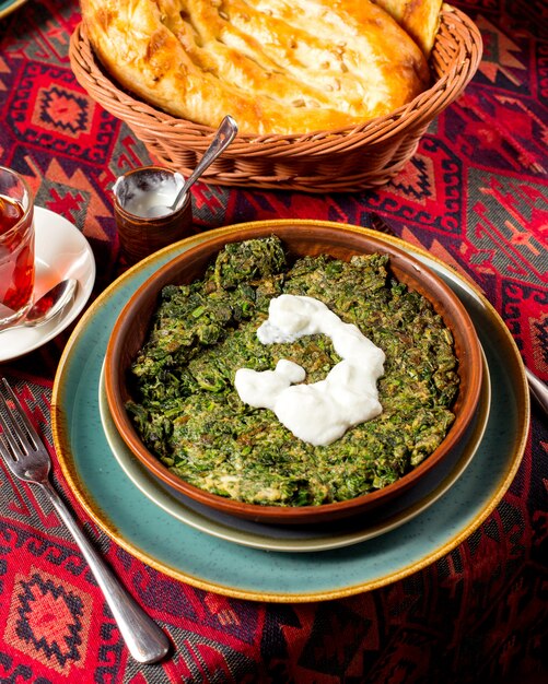 Azerbaijani dish kookoo cooked with herbs and eggs topped with yogurt