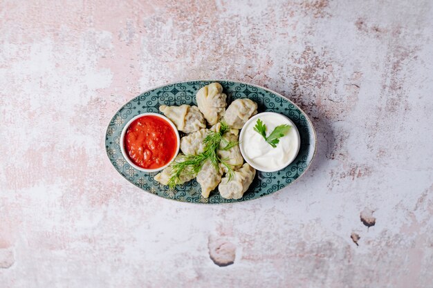 Azerbaijani dushbere, gurze, khingal with yogurt and tomato sauce.