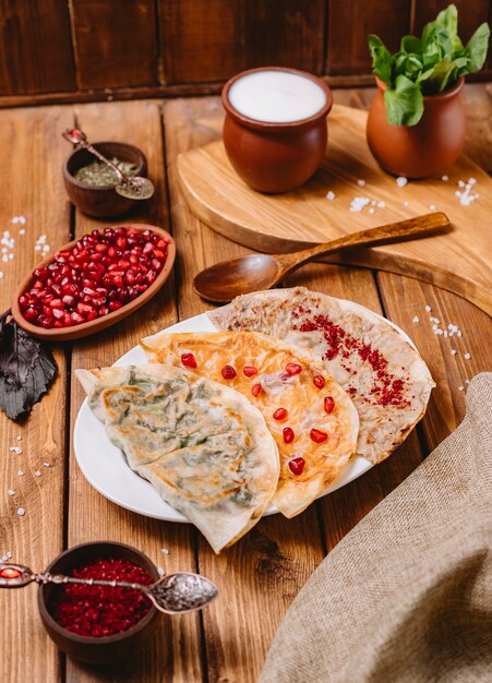 Azerbaijani gutabs platter with herbs pumpkin and meat served with yogurt