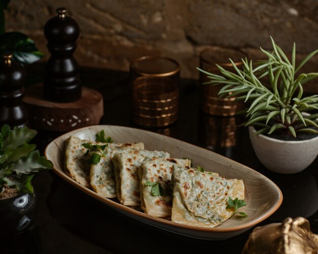 Azerbaijani kutab, gozleme finely roasted and served in a ceramic long plate