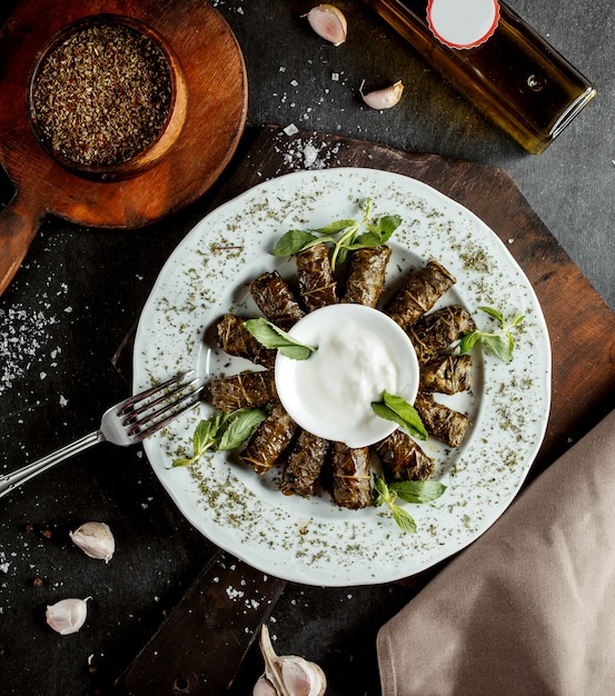 Dolma azero a foglie avvolte lunghe avvolto da yogurt e foglie di menta essiccate