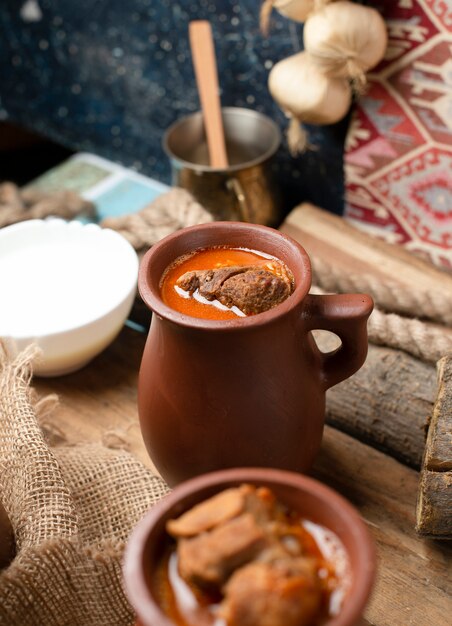 Azerbaijani meat stew piti with yogurt, on the wooden board.