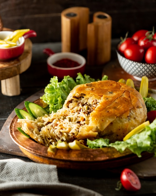 Free photo azerbaijani rice dish shah pilaf flatbread crust filled with rice meat and peas