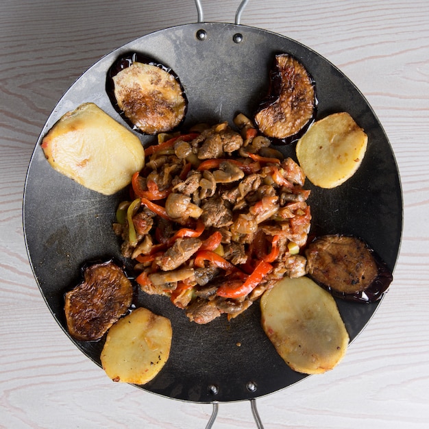 Free photo azerbaijani sac ichi in a black pan with mixed foods.