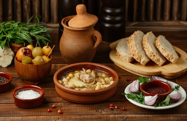 Azerbaijani traditional food piti in a pottery bowl served with sesammed bread