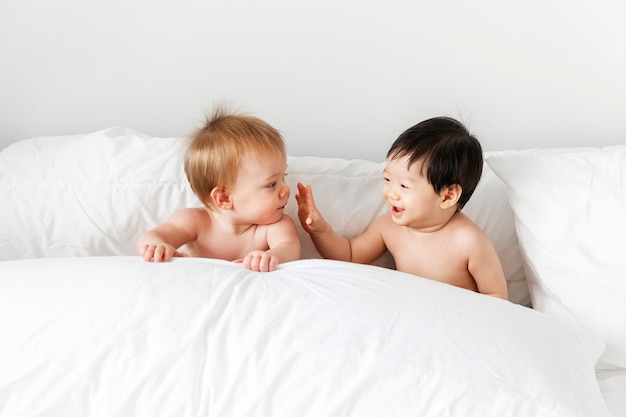 Babies playing on the bed