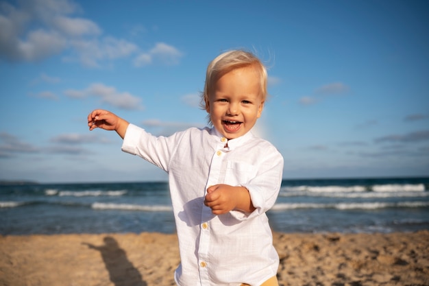 Foto gratuita bambino sulla spiaggia al tramonto