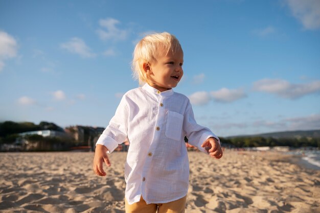 Foto gratuita bambino sulla spiaggia al tramonto