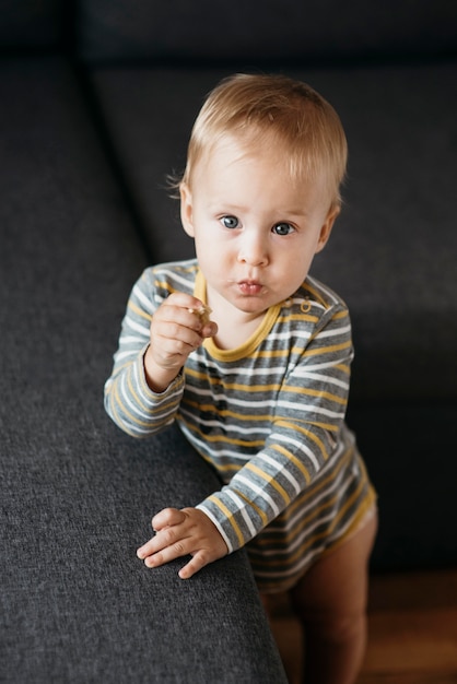 自宅のソファの横で食べる男の子