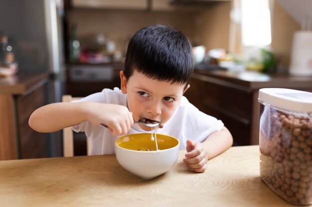 自宅で朝食を持っている男の子