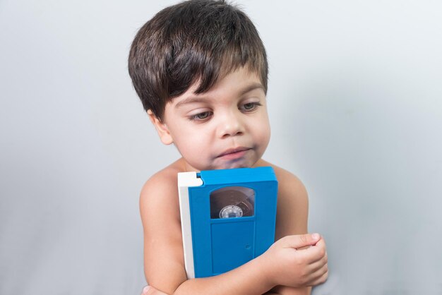 파란색 vhs 테이프를 들고 아기 소년