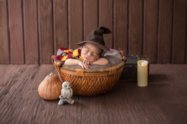 Free photo baby boy laying inside little basket with funny wizard costume