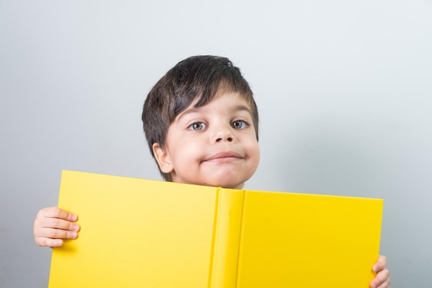 Baby boy reading yellow book