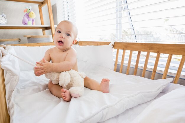 Baby boy sitting on a cradle