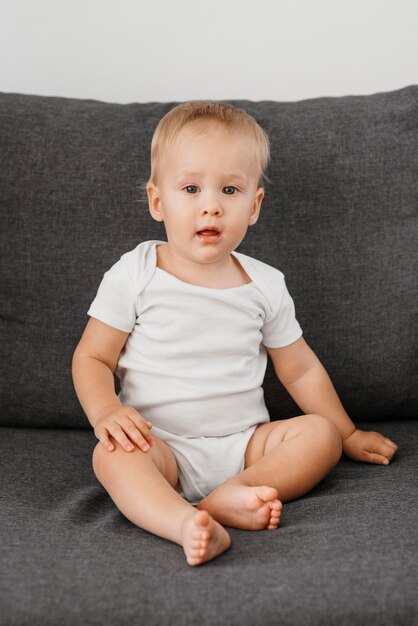 Baby boy sitting on the sofa waiting to eat