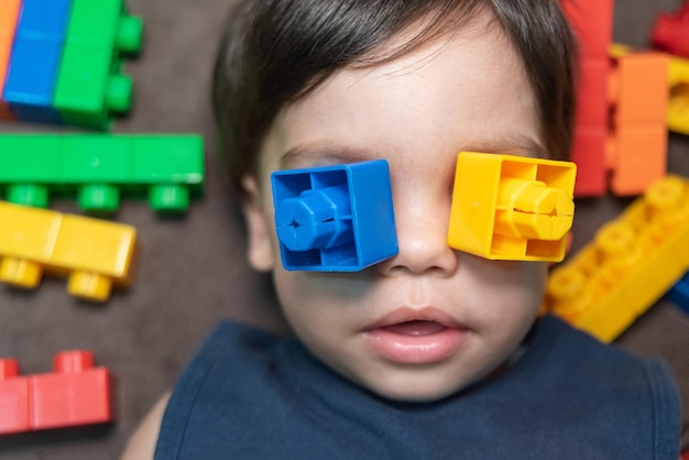 Free photo baby boy with blue eyes playing with building blocks