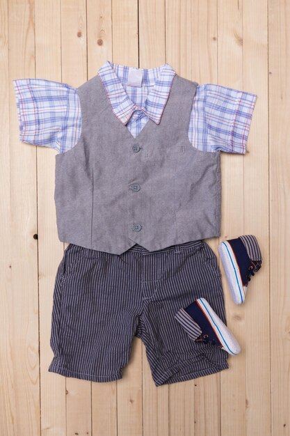 Baby clothes for boys on wooden background