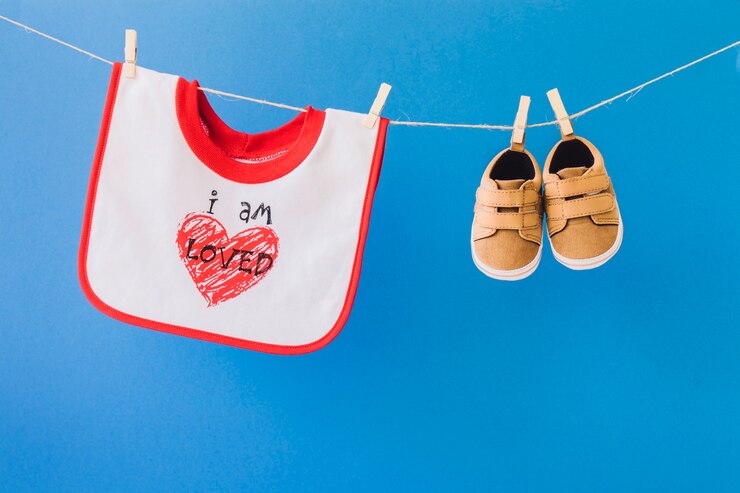Free Photo baby concept with bib and shoes on clothesline