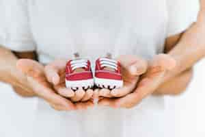 Free photo baby concept with hands holding shoes