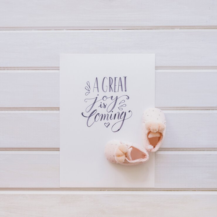 Free Photo baby concept with paper and pair of shoes