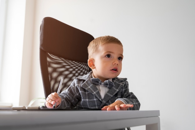 Foto gratuita bambino vestito da uomo d'affari