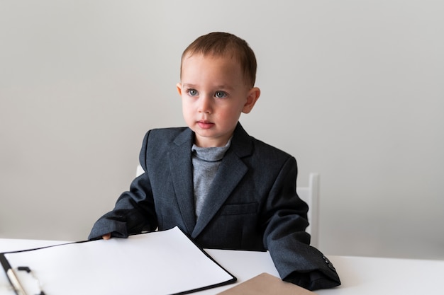 Foto gratuita bambino vestito da uomo d'affari