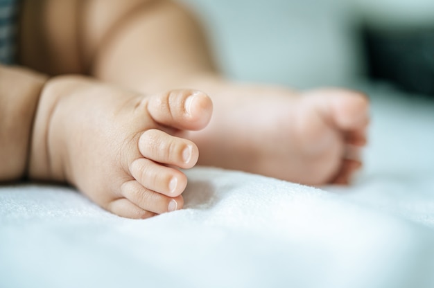 Baby feet in white bed.