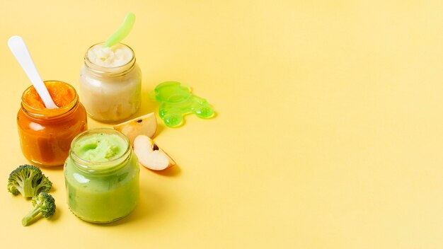 Baby food frame in jars on yellow background