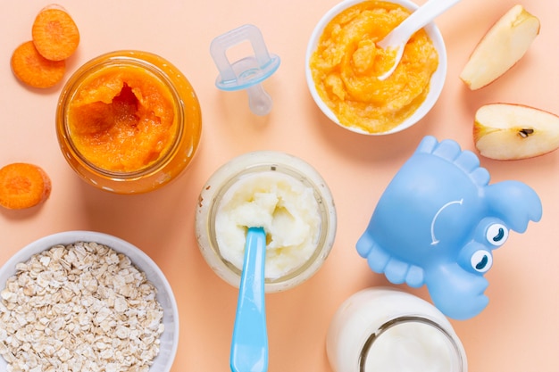 Baby food on pink background top view