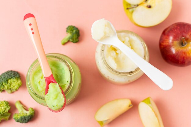 Baby food on pink background above view