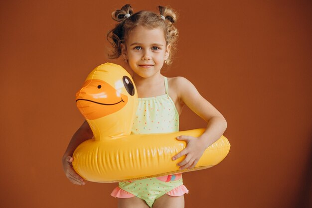 Baby girl isolated wearing swimsuit and rubber duck tube