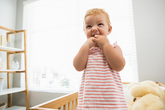 Baby girl playing in a cradle