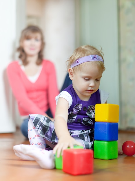 baby girl plays with blocks