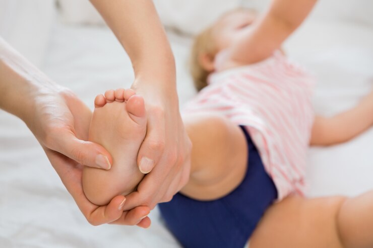 Free Photo baby girl receiving massage from mother