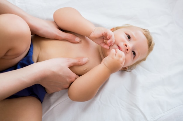 Baby girl receiving massage from mother