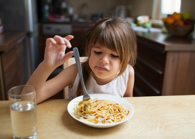 Foto gratuita neonata che rifiuta il piatto della pasta a casa