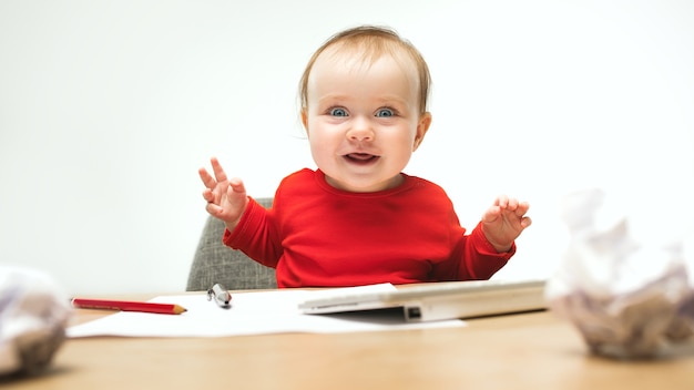 Baby girl sitting with cup of coffee and keyboard